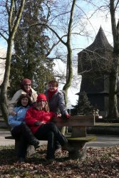 W tle drewniana dzwonnica przy kościele w Poniszowicach.